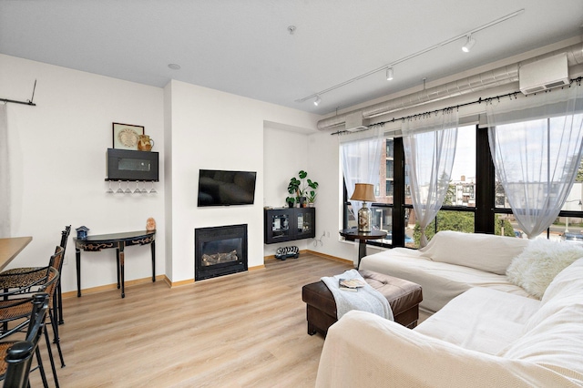 4525 Park Commons Dr Unit 221, Saint Louis Park, MN 55416 - living area featuring light wood-style flooring, a wealth of natural light, baseboards, and a glass covered fireplace