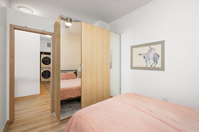 4525 Park Commons Dr Unit 221, Saint Louis Park, MN 55416 - bedroom with light wood finished floors and stacked washer and dryer