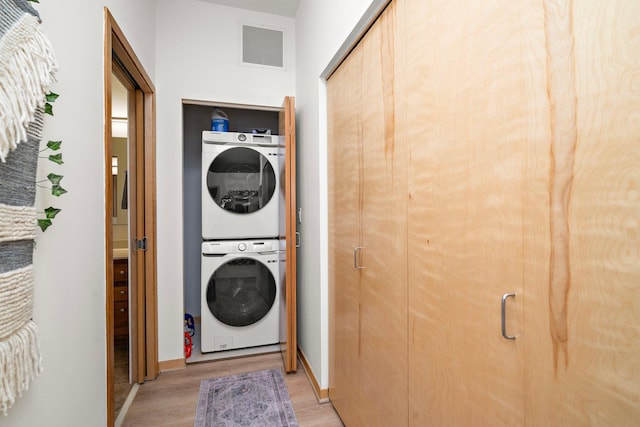 4525 Park Commons Dr Unit 221, Saint Louis Park, MN 55416 - clothes washing area featuring laundry area, visible vents, light wood-style flooring, stacked washing maching and dryer, and baseboards