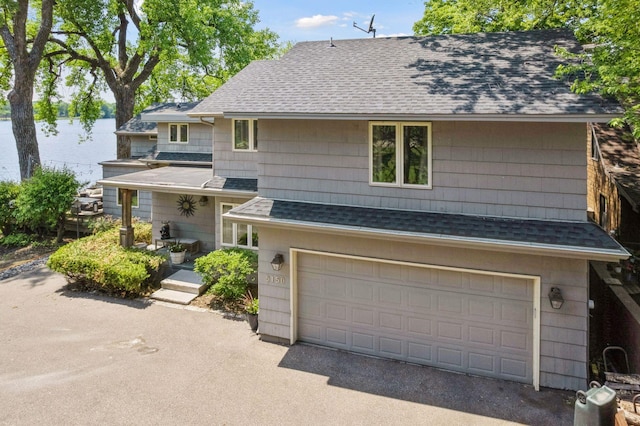 5150 Meadville St, Greenwood, MN 55331 - view of front of house with a shingled roof, an attached garage, and a water view