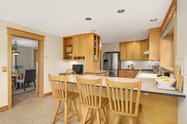 12697 177th St N, May Twp, MN 55047 - kitchen with stainless steel fridge with ice dispenser, open shelves, tasteful backsplash, a peninsula, and a breakfast bar area