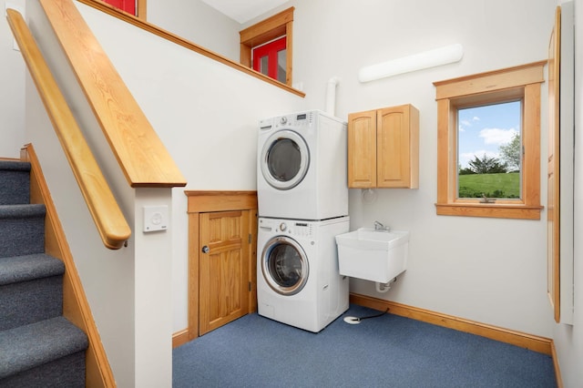 12697 177th St N, May Twp, MN 55047 - laundry area featuring stacked washer and clothes dryer, cabinet space, carpet floors, and baseboards