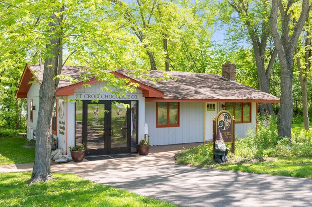 12697 177th St N, May Twp, MN 55047 - view of front of home featuring a chimney, french doors, roof with shingles, and a cooling unit