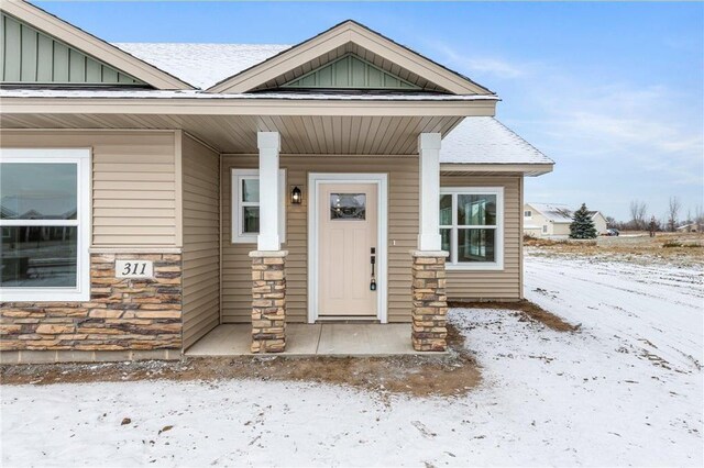 260 Spring St, Osceola, WI 54020 - snow covered property entrance featuring stone siding