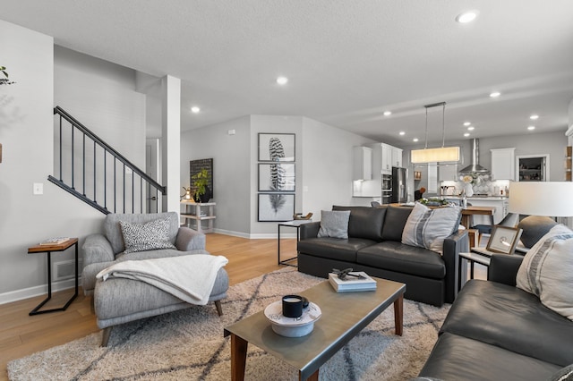 living area featuring stairs, recessed lighting, and light wood finished floors