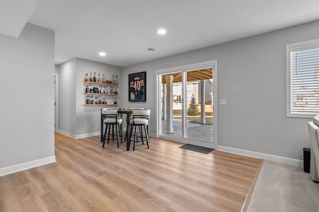 dining area with a bar, plenty of natural light, baseboards, and recessed lighting