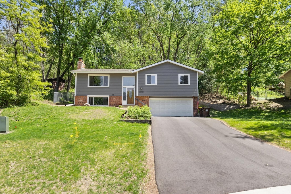 12701 Pheasant Run, Burnsville, MN 55337 - raised ranch featuring brick siding, a chimney, driveway, and an attached garage
