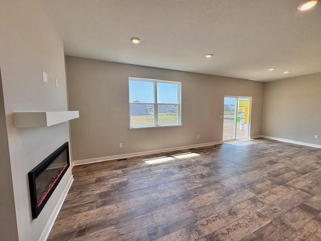 6187 Jensen Alcove S, Cottage Grove, MN 55016 - unfurnished living room with dark wood-type flooring, a large fireplace, and recessed lighting