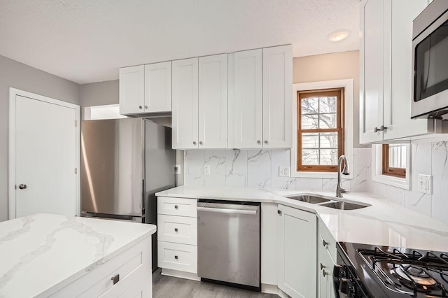 5298 Park Dr, Savage, MN 55378 - kitchen with a sink, light stone counters, backsplash, and appliances with stainless steel finishes