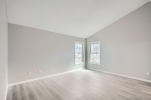 5298 Park Dr, Savage, MN 55378 - empty room with lofted ceiling, baseboards, light wood finished floors, and a textured ceiling