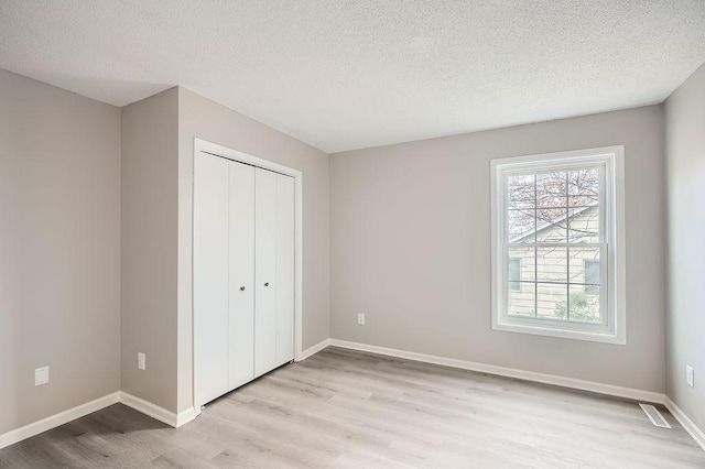 5298 Park Dr, Savage, MN 55378 - unfurnished bedroom featuring a closet, light wood-style flooring, a textured ceiling, and baseboards