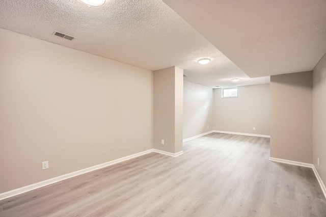 5298 Park Dr, Savage, MN 55378 - basement with visible vents, baseboards, a textured ceiling, and light wood-style flooring