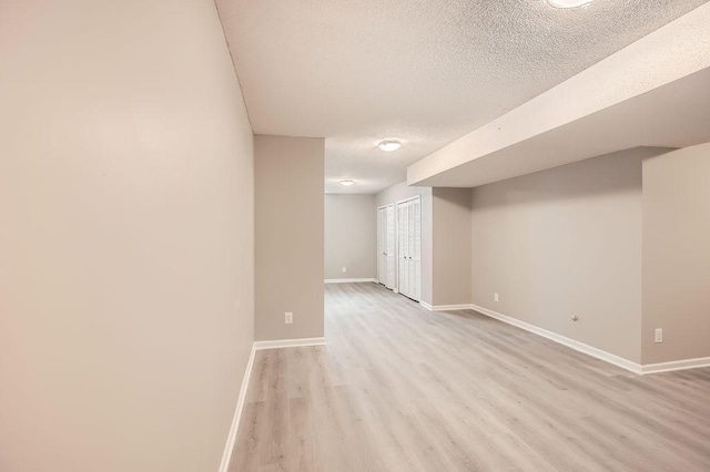 5298 Park Dr, Savage, MN 55378 - finished below grade area with light wood-style floors, baseboards, and a textured ceiling