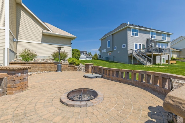 view of patio featuring stairway, an outdoor fire pit, a deck, and a residential view