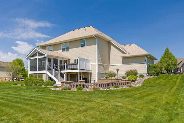 rear view of property with a sunroom, a yard, a patio, and a deck