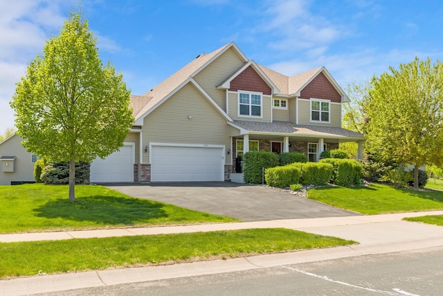 craftsman-style house featuring driveway, a front lawn, an attached garage, and a shingled roof