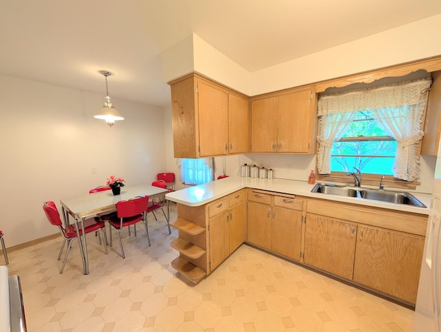kitchen with a sink, light countertops, a peninsula, light floors, and open shelves