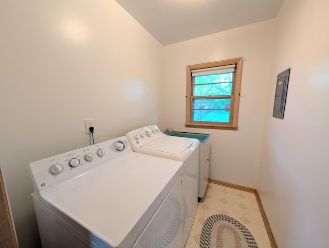 clothes washing area with washer and dryer, electric panel, and baseboards