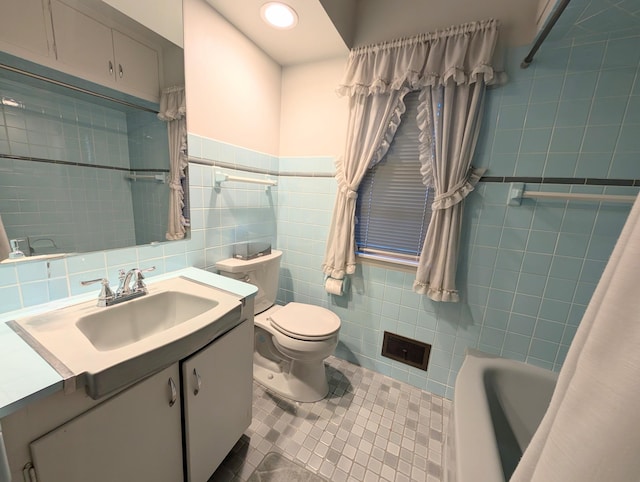 full bathroom featuring tile walls, tile patterned flooring, toilet, vanity, and shower / bath combo