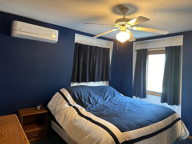 bedroom with an AC wall unit, a ceiling fan, and a textured ceiling