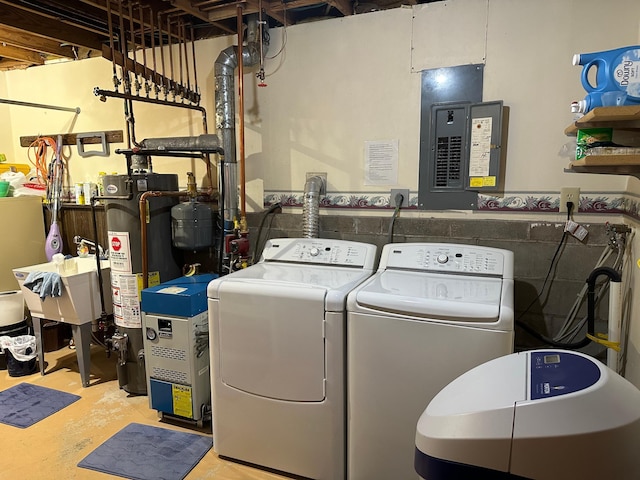washroom with gas water heater, laundry area, washer and clothes dryer, and electric panel