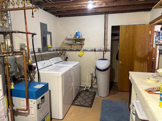 clothes washing area featuring washer and dryer, a heating unit, laundry area, and electric panel