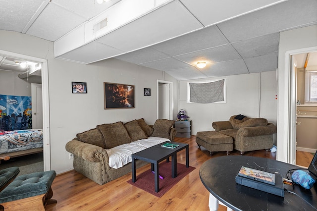 living room featuring visible vents, a drop ceiling, and light wood-style floors