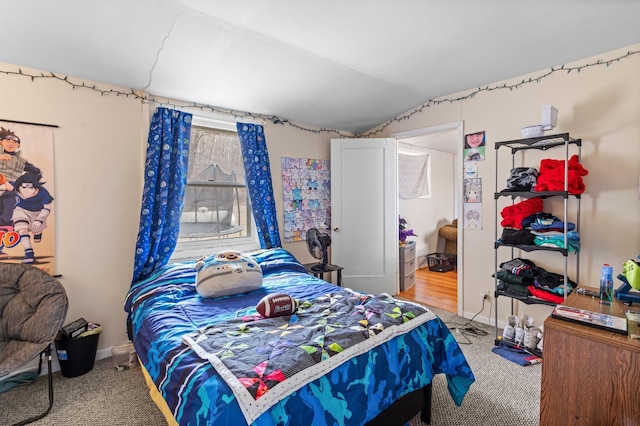 bedroom with lofted ceiling, carpet, and baseboards