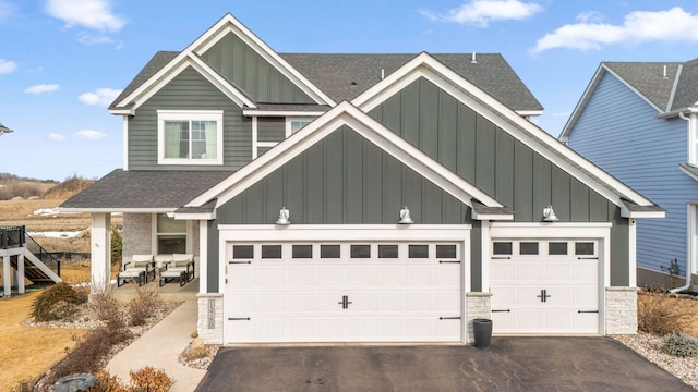 view of front of house with board and batten siding, driveway, and a shingled roof