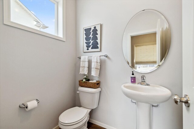 half bathroom with toilet and baseboards