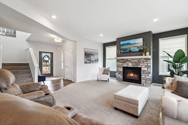 living area with carpet flooring, plenty of natural light, baseboards, and stairs