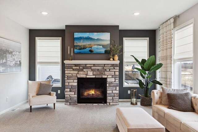 carpeted living area with visible vents, recessed lighting, a fireplace, and baseboards