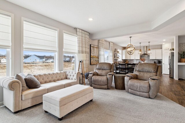 living area with recessed lighting, a notable chandelier, and wood finished floors