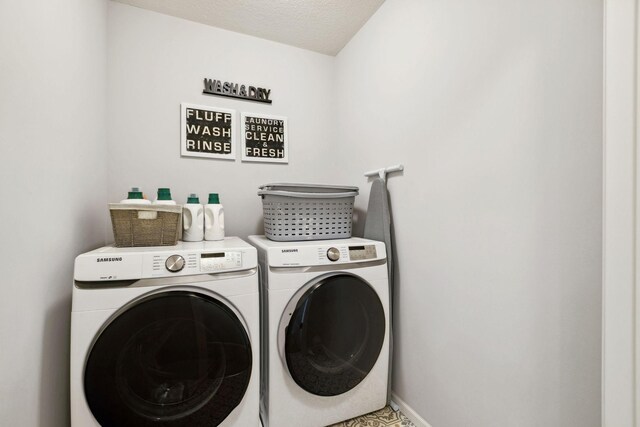 laundry area featuring baseboards, a textured ceiling, independent washer and dryer, and laundry area