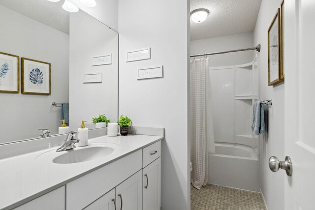 bathroom with a textured ceiling, vanity, and shower / bathtub combination with curtain