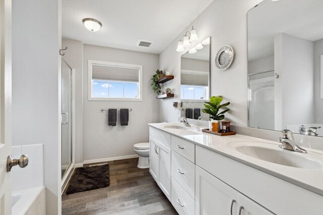 bathroom with visible vents, a shower stall, wood finished floors, and a sink