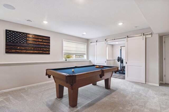 rec room with a barn door, light colored carpet, and baseboards