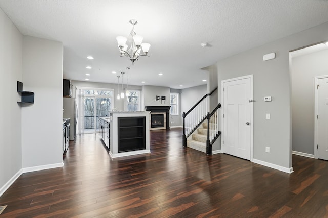 interior space featuring a chandelier, dark wood-style flooring, baseboards, and stairs