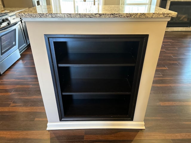 interior details with electric range, light stone counters, and dark wood-style floors