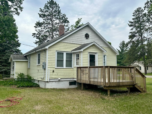 329 Main St NW, Menahga, MN 56464 - rear view of house with a deck, a chimney, a yard, and roof with shingles