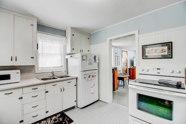 329 Main St NW, Menahga, MN 56464 - kitchen featuring white appliances, a sink, light countertops, crown molding, and white cabinetry