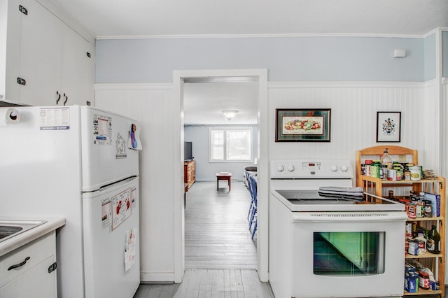 329 Main St NW, Menahga, MN 56464 - kitchen featuring white appliances, crown molding, light wood-style flooring, white cabinetry, and light countertops