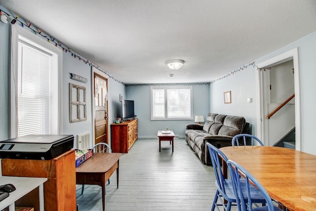 329 Main St NW, Menahga, MN 56464 - living area with hardwood / wood-style flooring, a textured ceiling, and stairway