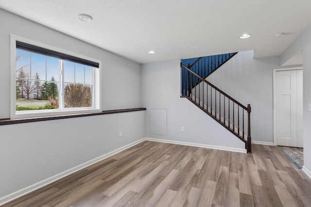 8949 Village Loop, Chanhassen, MN 55317 - unfurnished room featuring wood finished floors, stairway, recessed lighting, baseboards, and a smoke detector