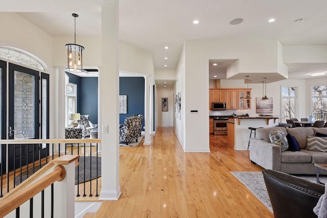 living room with light wood-style floors, recessed lighting, and baseboards