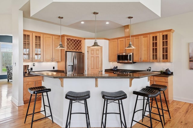 kitchen with recessed lighting, a breakfast bar area, a spacious island, appliances with stainless steel finishes, and light wood-type flooring