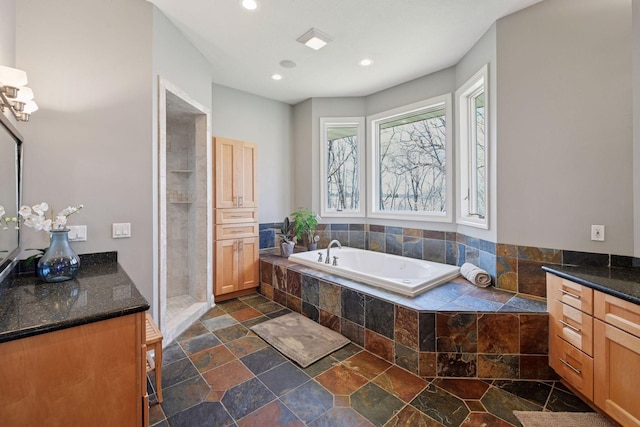 full bathroom featuring recessed lighting, a bath, vanity, stone tile floors, and a stall shower