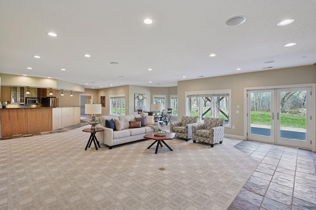 living room with recessed lighting, light colored carpet, french doors, and baseboards