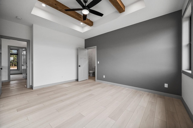 unfurnished bedroom with a raised ceiling, baseboards, beamed ceiling, and light wood-style flooring