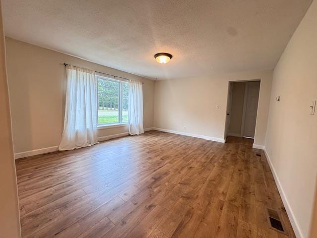 222 Dogwood Ave NW, Menahga, MN 56464 - empty room with wood finished floors and a textured ceiling